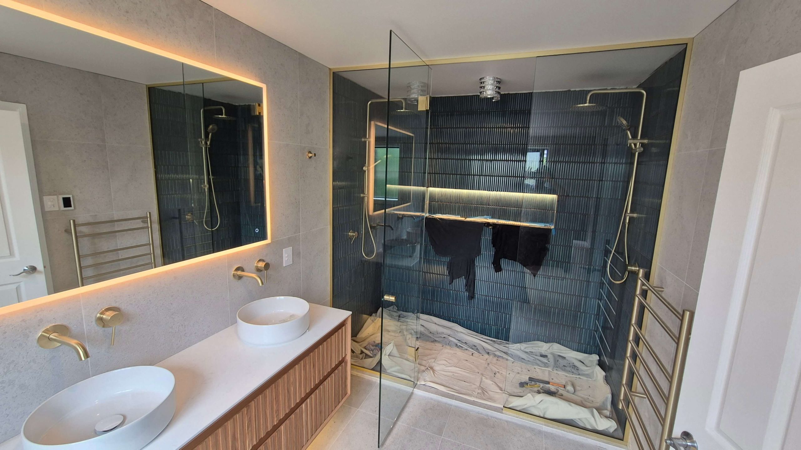Luxury bathroom renovation Christchurch with double vanity, LED mirror, and gold fixtures